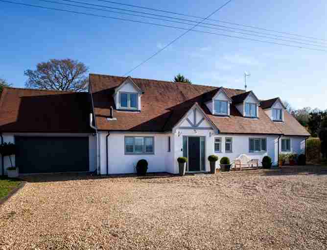 Large home with casement windows and gravel driveway